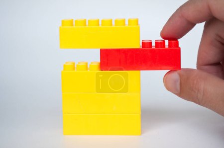 Hand pulling red lego from the rest. Building concept.