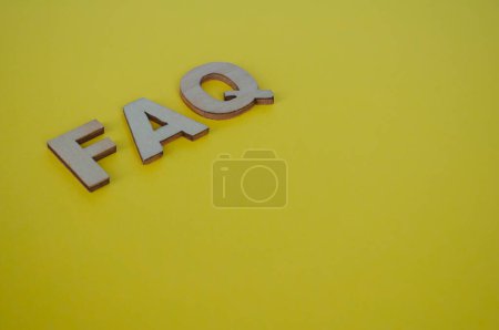Téléchargez les photos : FAQ lettres en bois sur fond jaune. Concept de questions et réponses. - en image libre de droit