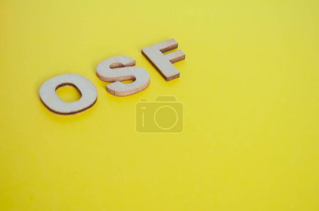 Photo for OSF wooden letters representing Open Science Framework on yellow background. - Royalty Free Image