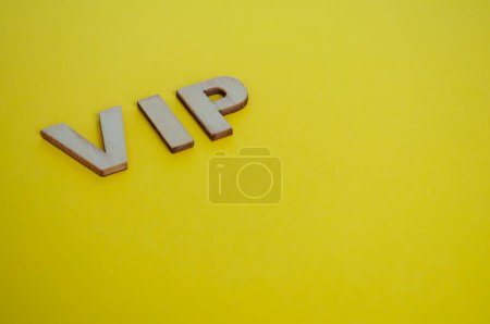 Cartas de madera VIP que representan a personas muy importantes sobre fondo amarillo.