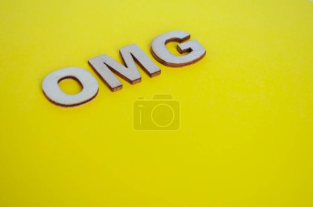 Foto de OMG letras de madera que representan Oh Mi Dios sobre fondo amarillo. - Imagen libre de derechos