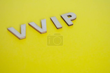 VIP-Holzbuchstaben, die sehr wichtige Menschen auf gelbem Hintergrund darstellen.