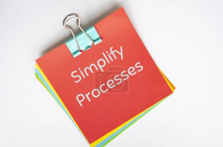 simplify processes text on red notepad on white background.
