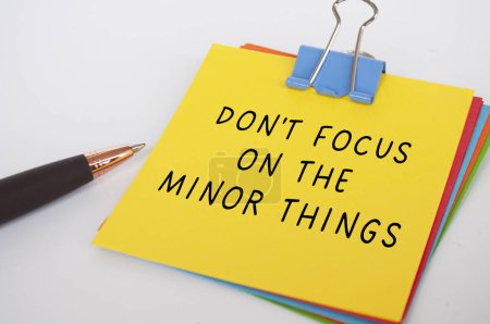 Don't Focus on the minor things text on yellow notepad. Encouragement concept.