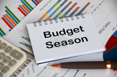 Budget season text on notepad with business analysis background.