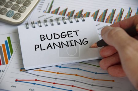 Budget planning text on notepad with business analysis background.