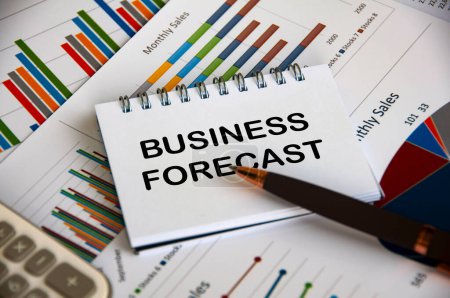 Business forecast text on notepad with business analysis background.