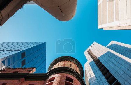 Foto de Adelaide City, Australia Meridional - 23 de agosto de 20019: Edificios de gran altura miran al cielo azul en el centro de Adelaida mientras miran hacia arriba en un día desde el suelo - Imagen libre de derechos