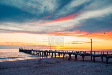 Téléchargez les photos : Henley Beach jetée au crépuscule avec la mer tranquille embrassant les piliers et les nuages altérés au-dessus, Australie du Sud - en image libre de droit