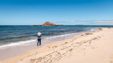 Foto de Mujer caminando por la playa vacía descalza y con sombrero, Marion Bay, Australia Meridional - Imagen libre de derechos