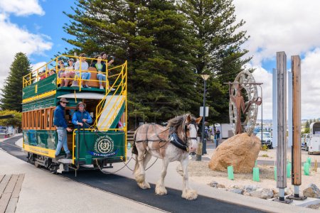 Téléchargez les photos : Victor Harbor, Australie du Sud - 5 janvier 2022 : Victor Harbor Horse Tram tracté avec des personnes se dirigeant vers l'île Granite via la chaussée nouvellement construite par un jour lumineux. - en image libre de droit