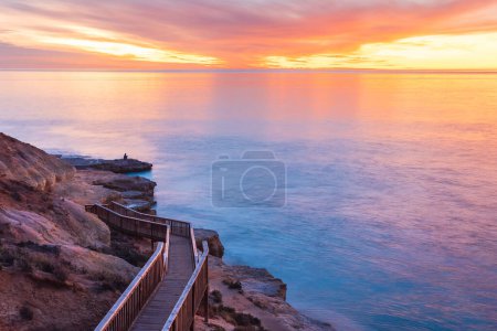 Southport Strandpromenade in Richtung Ozean mit der Silhouette eines Fischers an Land, Südaustralien