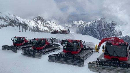 Foto de Máquinas de nieve que operan en Zugspitze, la montaña más alta de Alemania en los Alpes bávaros cubiertos de nieve cerca de Garmisch Patenkirchen - Imagen libre de derechos
