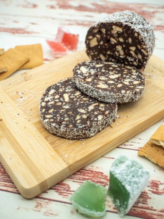 Photo for Slices chocolate salami with biscuits on a cutting board with turkish delight and biscuits aside - Royalty Free Image
