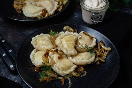 Vareniki con patatas y cebollas en un plato. Alimentos ucranianos