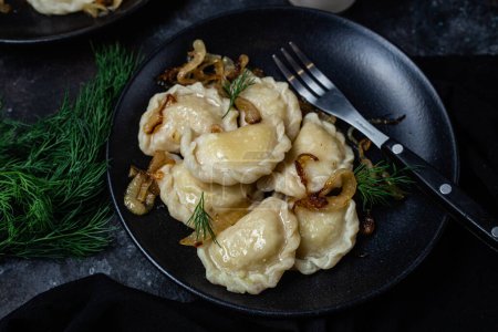 Téléchargez les photos : Vareniki avec pommes de terre et oignons dans une assiette. nourriture ukrainienne - en image libre de droit