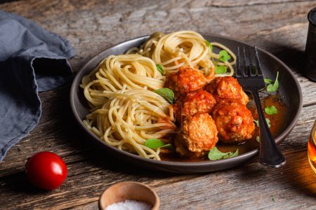 Photo for Pasta with meatballs and sauce in a plate on a wooden table - Royalty Free Image