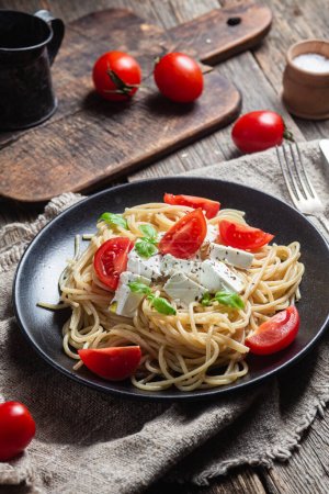 Photo for Spaghetti with feta cheese and tomatoes in a plate. Italian pasta - Royalty Free Image