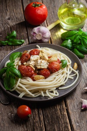 Italian pasta. Spaghetti with baked feta cheese and tomatoes in a bowl