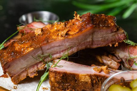 Téléchargez les photos : Côtes de porc grillées sur une planche de bois avec sauce - en image libre de droit