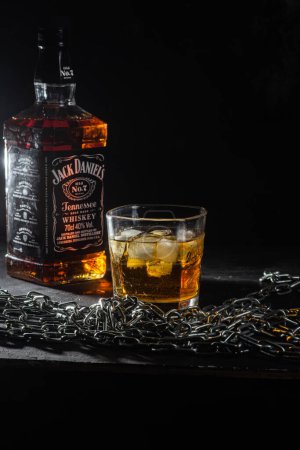 Téléchargez les photos : Bouteille de whisky Jack Daniels sur fond sombre - en image libre de droit