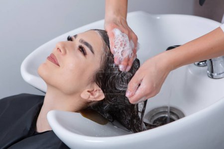 Photo for Professional hairdresser washing hair of young woman in beauty salon. close up of woman's hair in beauty salon, hairstyle concept - Royalty Free Image