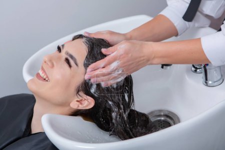 Photo for Professional hairdresser washing hair of young woman in beauty salon. close up of woman's hair in beauty salon, hairstyle concept - Royalty Free Image