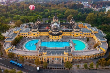 Téléchargez les photos : Budapest, Hongrie - Vue aérienne sur le bain thermal Szechenyi à côté du parc municipal. Ballonfly à l'arrière-plan. - en image libre de droit