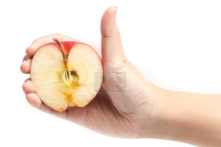 Main tenant à moitié coupé pomme rouge biologique frais délicieux fruit avec pouce doigt isolé sur fond blanc chemin de coupe