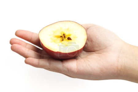 Main tenant à moitié coupé pomme rouge biologique fraîche délicieux fruits isolés sur fond blanc chemin de coupe