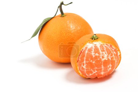 Photo for Half peeled and whole fresh organic orange delicious fruit with green leaves isolated on white background clipping path - Royalty Free Image
