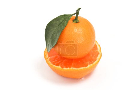 Half cut fresh organic orange delicious fruit side view with green leaves isolated on white background clipping path