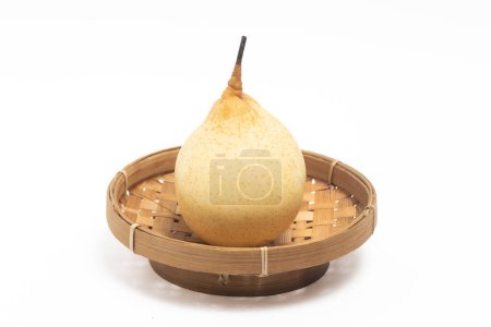 Fresh organic yellow pear delicious fruit in a bamboo basket plate isolated on white background clipping path