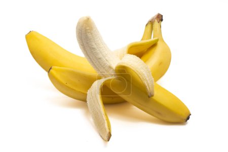 Foto de Medio pelado y un montón de plátanos orgánicos frescos deliciosa fruta aislada en el camino de recorte de fondo blanco - Imagen libre de derechos