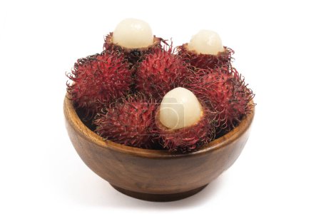 Halb geschnitten und frische Bio-Rambutan köstliche Früchte in einer hölzernen Schüssel isoliert auf weißem Hintergrund Clipping Pfad