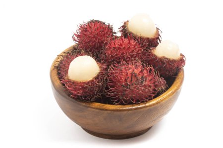 Halb geschnitten und frische Bio-Rambutan köstliche Früchte in einer hölzernen Schüssel isoliert auf weißem Hintergrund Clipping Pfad