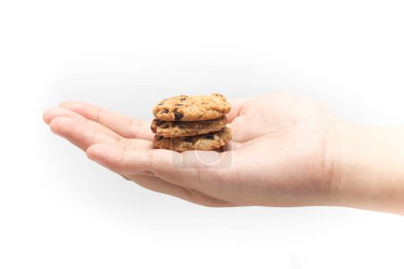 Stacked of chocolate chip cookies in open hand isolated on white background clipping path