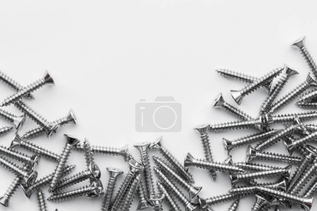 Téléchargez les photos : Screws, stainless nuts and bolts on grunge metal background. top view Picture space for text message, flat lay Banner for website. - en image libre de droit