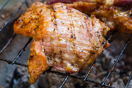 Photo for Grilled chicken thigh on the flaming grill - Royalty Free Image
