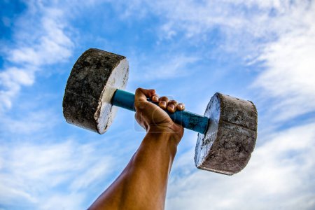 Photo for Man practicing with a old dumbbell. Exercise for good health. - Royalty Free Image