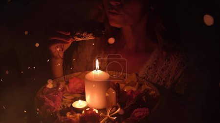 Téléchargez les photos : Encens dans une main de femme, fumée d'encens sur fond noir - en image libre de droit