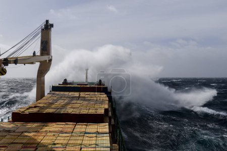 Photo for Cargo vessel with deck cargo at stormy sea. View from navigational bridge. Stormy sea, Bad weather. Gale. Rough sea. - Royalty Free Image