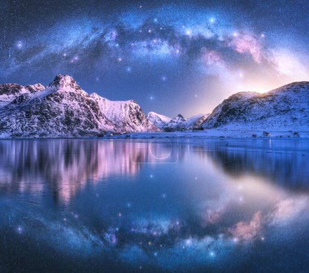 Photo for Milky Way arch above sea coast and snow covered mountains in winter at night. Lofoten Islands, Norway. Arctic landscape with starry sky, arched milky way reflected in water, snowy rocks. Space - Royalty Free Image
