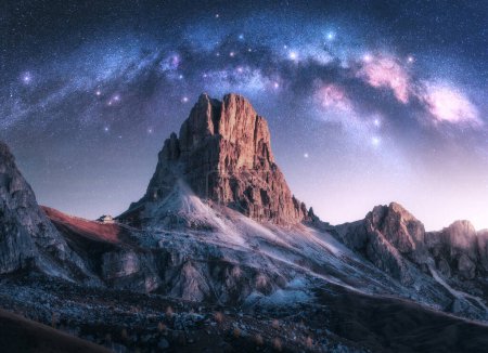 Photo for Milky Way acrh over beautifull rocks at starry night in autumn in Dolomites, Italy. Landscape with purple sky with stars and bright arched milky way over high alpine rocky mountains. Space. Nature - Royalty Free Image