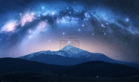 Photo for Milky Way over the beautiful Goverla mountain with snow covered peak at night in summer in Ukraine. Colorful landscape with bright starry sky with Milky Way arch, snowy rocks, hills. Space. Nature - Royalty Free Image