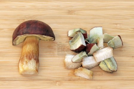 Photo for Half and sliced edible mushroom Imleria badia, commonly known as bay bolete. Pores and flesh stain dull blue to bluish-grey when bruised or cut. Fruit bodies have a chestnut to dark brown cap. - Royalty Free Image