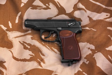 Photo for Makarov pistol on a background of desert camouflage. Russian weapons. - Royalty Free Image
