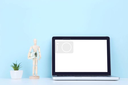 Photo for Laptop computer with wooden figure and dollar banknotes on blue background - Royalty Free Image