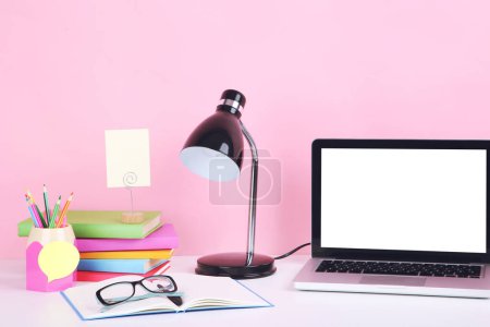 Photo for Laptop computer with books, pencils and electrical lamp on pink background - Royalty Free Image