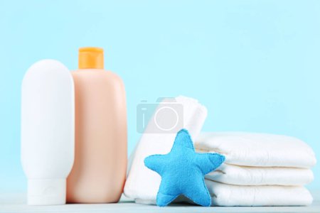 Photo for Baby diapers with bottles and star toy on blue background - Royalty Free Image
